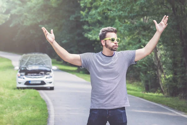 Pilote stressé et frustré debout sur la route à côté de la voiture cassée. Problèmes de route et concepts d'assistance . — Photo