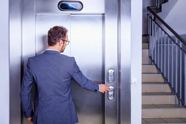 Young professional in suit waiting in front of the elevator — Stock Photo, Image