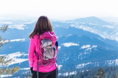 Kar Dağı tepesinde sırt çantası ile kadın otostopçu.