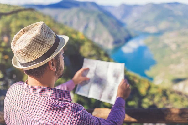 Viajante segurando mapa e olhando para o plano de trekking na colina acima bela paisagem canyon . — Fotografia de Stock