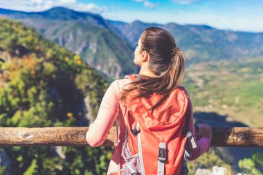 Genç yürüyüşçünün bir dağın tepesindeki manzarası kanyon nehri manzarasına sahip. Özgürlük kavramı.