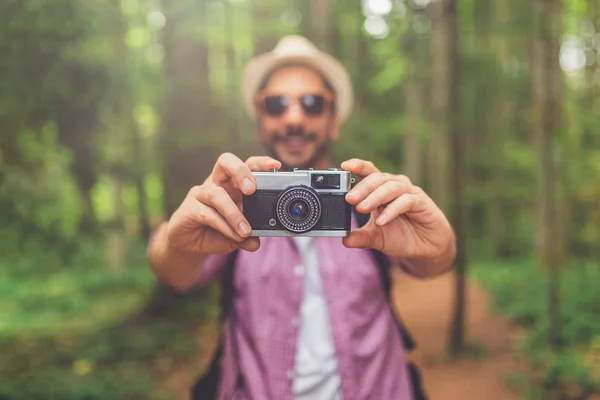 森の中でレトロな写真カメラを持つ若い観光客。旅行のコンセプト. — ストック写真