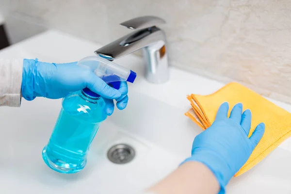 バスルームで流域を消毒するためにマイクロファイバークロスとスプレーボトル消毒剤を保持ゴム手袋を身に着けている女性の手 ウイルスや細菌の概念からの保護 — ストック写真