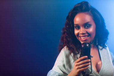 Sahnede bir caz şarkıcısı sahne alıyor. Afro.