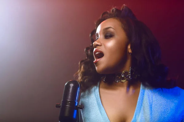 Sahnede bir caz şarkıcısı sahne alıyor. Afro.