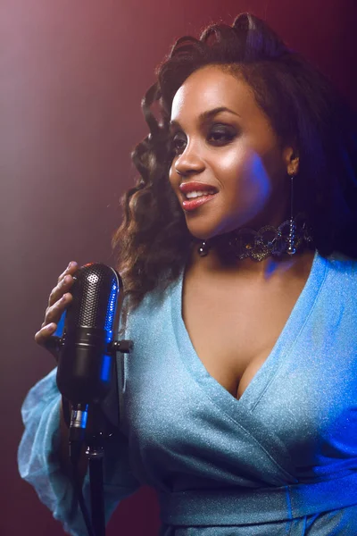 Sahnede bir caz şarkıcısı sahne alıyor. Afro.