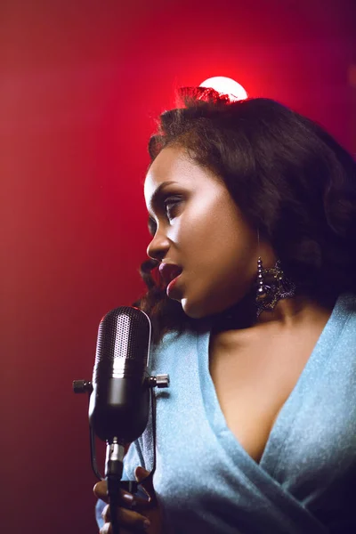 Sahnede bir caz şarkıcısı sahne alıyor. Afro.