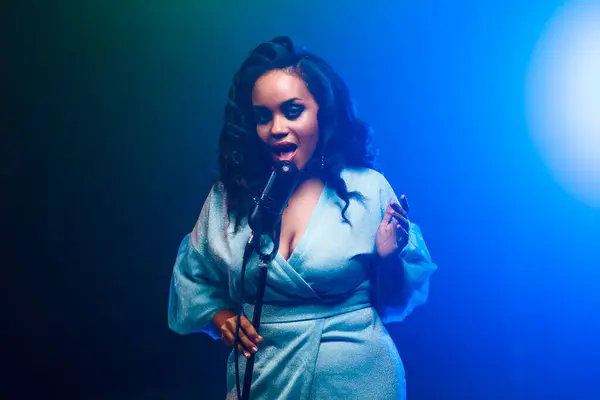 Sahnede bir caz şarkıcısı sahne alıyor. Afro.