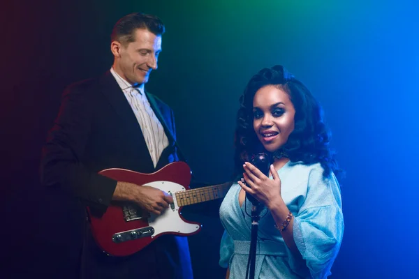 Sahnede bir caz şarkıcısı sahne alıyor. Afro.