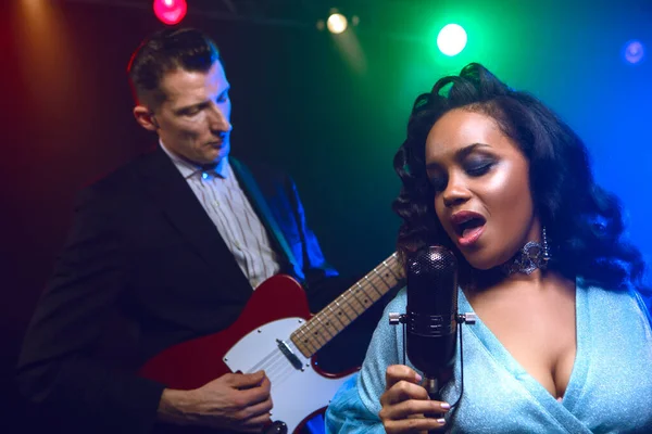 Sahnede bir caz şarkıcısı sahne alıyor. Afro.