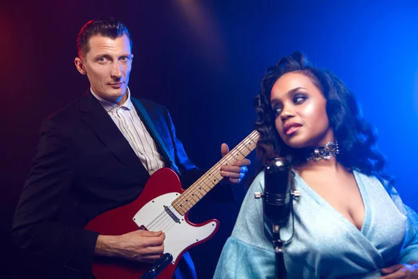 Sahnede bir caz şarkıcısı sahne alıyor. Afro.