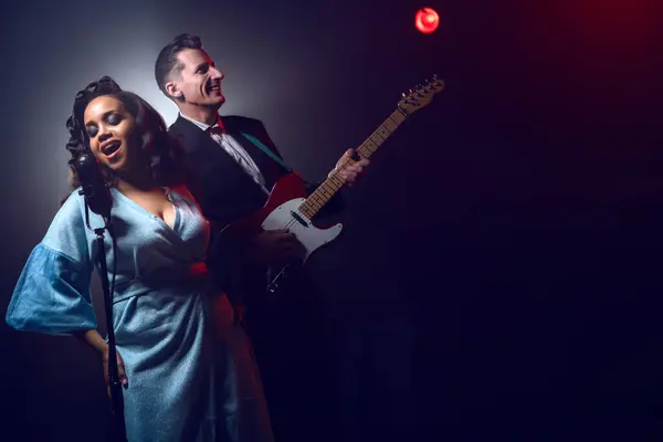 Sahnede bir caz şarkıcısı sahne alıyor. Afro.