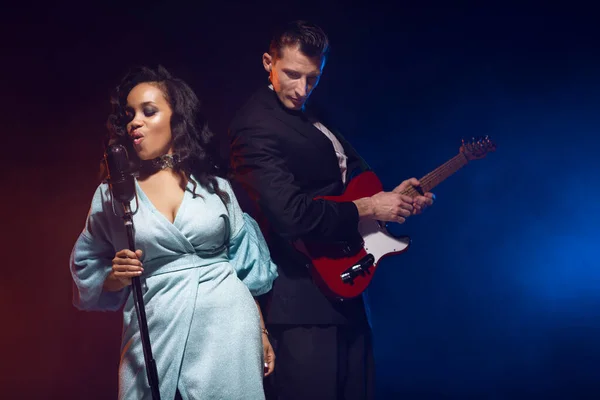 Sahnede bir caz şarkıcısı sahne alıyor. Afro.