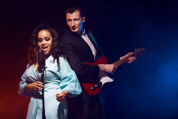 Sahnede bir caz şarkıcısı sahne alıyor. Afro.