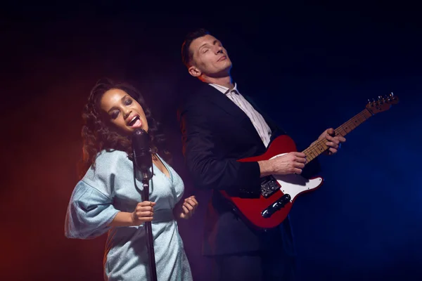 Sahnede bir caz şarkıcısı sahne alıyor. Afro.