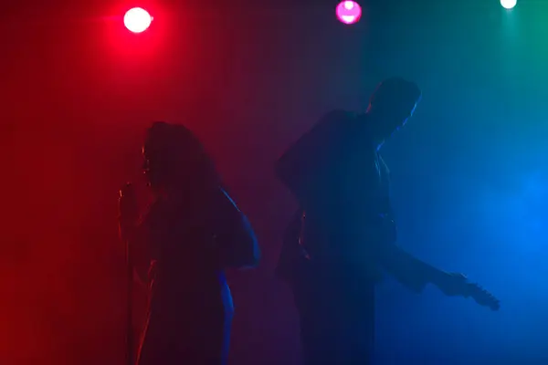 Sahnede bir caz şarkıcısı sahne alıyor. Afro.