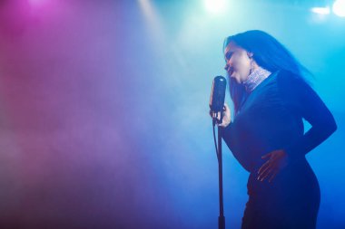 Sahnede bir caz şarkıcısı sahne alıyor. Afro.