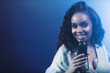 Sahnede bir caz şarkıcısı sahne alıyor. Afro.