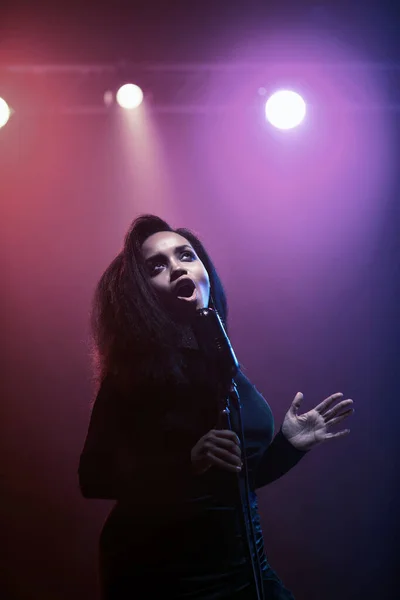 Sahnede bir caz şarkıcısı sahne alıyor. Afro.