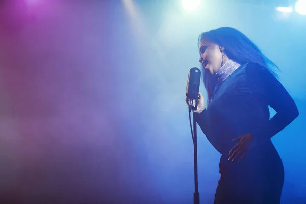 Sahnede bir caz şarkıcısı sahne alıyor. Afro.