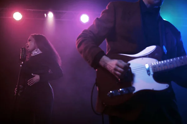 Sahnede bir caz şarkıcısı sahne alıyor. Afro.