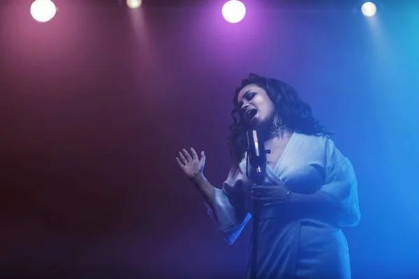 Sahnede bir caz şarkıcısı sahne alıyor. Afro.