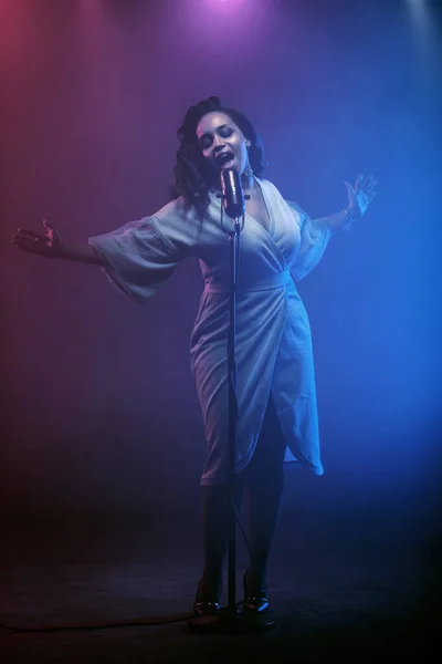 Sahnede bir caz şarkıcısı sahne alıyor. Afro.