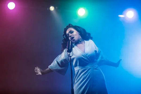 Sahnede bir caz şarkıcısı sahne alıyor. Afro.