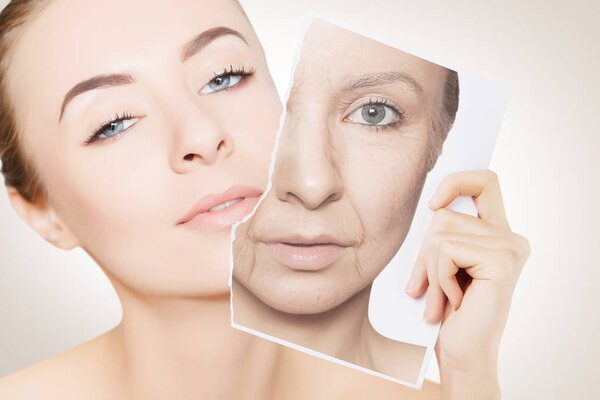 closeup portrait of young woman face holding portrait with old wrinkled face