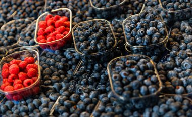 dükkan tezgahında yaban mersini ve ahududu