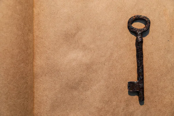 Old key on vintage paper background — Stock Photo, Image