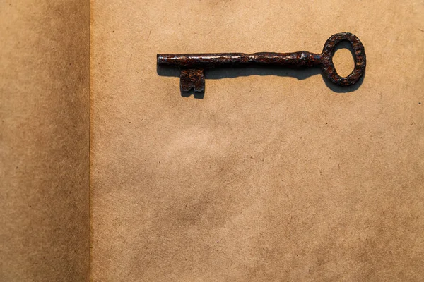 Old key on vintage paper background — Stock Photo, Image