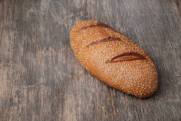 Nybakat välsmakande bröd på en träyta — Stockfoto