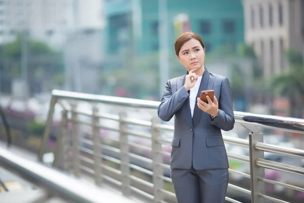 Geschäftsfrau nutzt Smartphone und hat nagendes Denken — Stockfoto