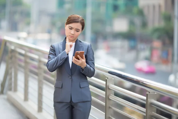 Frau tippt Smartphone und ist traurig — Stockfoto