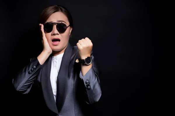 Mujer con gafas de sol en traje negro comprobar su reloj ella es la —  Fotos de Stock