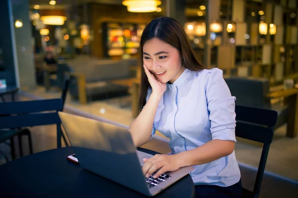 Glückliche Frau benutzt Laptop in der Nacht im Café — Stockfoto