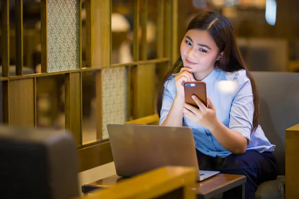Glückliche Frau nutzt Smartphone nachts im Café — Stockfoto