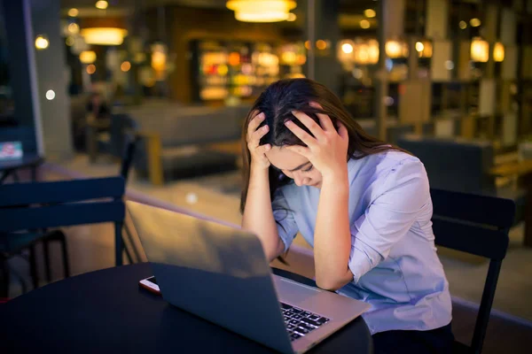 Mujer usando el ordenador portátil en la noche en el café se siente preocupada — Foto de Stock
