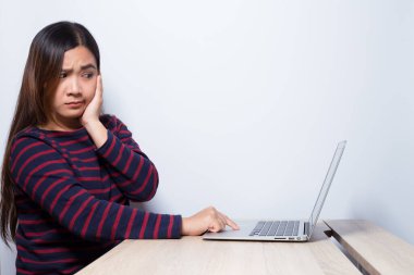 Kadın bilgisayar kullanıyor ve bir şeyi şaşırtıyor.