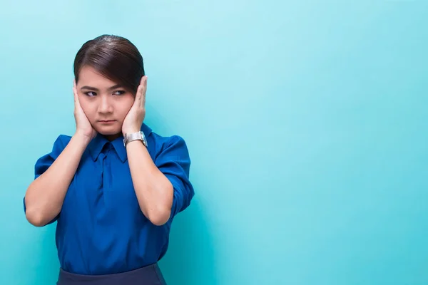 Asian woman covers ears with hands on isolated background — Stock Photo, Image