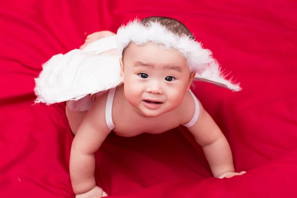 Sad baby cupid on red background — Stock Photo, Image