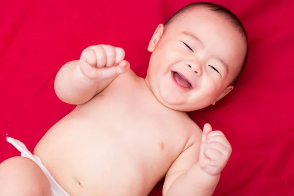 Heureux asiatique bébé sur rouge fond — Photo