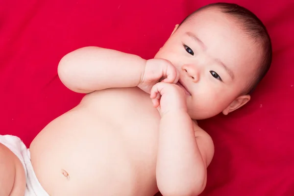 Feliz asiático bebê no fundo vermelho — Fotografia de Stock