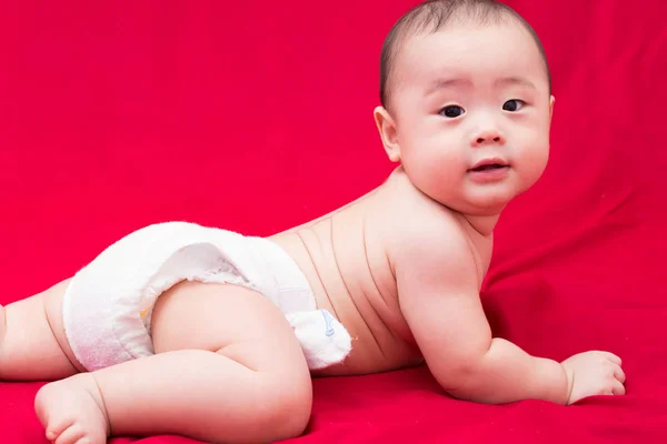 Feliz asiático bebê no fundo vermelho — Fotografia de Stock