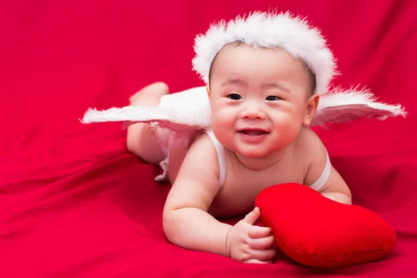 Cupido bebé sobre fondo rojo —  Fotos de Stock