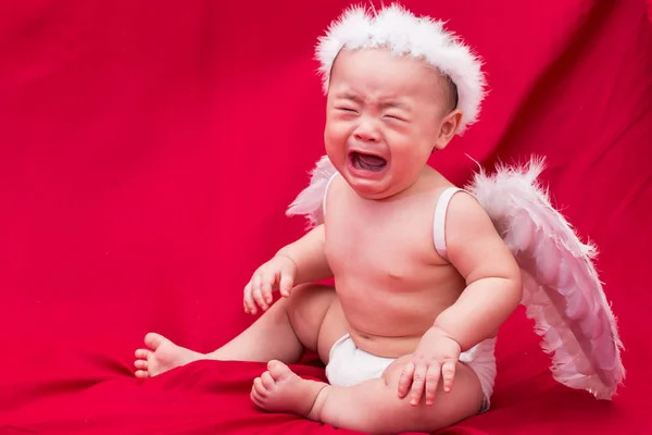 Cupido bambino triste su sfondo rosso — Foto Stock