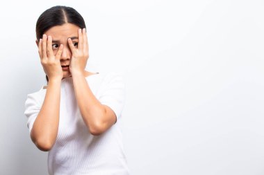 Beyaz arka planda yalnız duran korkmuş kadın.