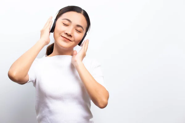 Kvinna i hörlurar lyssnar på musik isolerad över vit bakgrund — Stockfoto