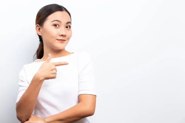 Happy woman is pointing to copy space isolated over white backgr — ストック写真